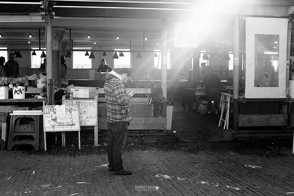 Checking his phone in the light.